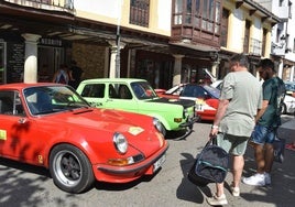 Curiosos observan uno de los coches clásicos que este sábado han participado en el XV Rallye Montaña Palentina de Cervera.