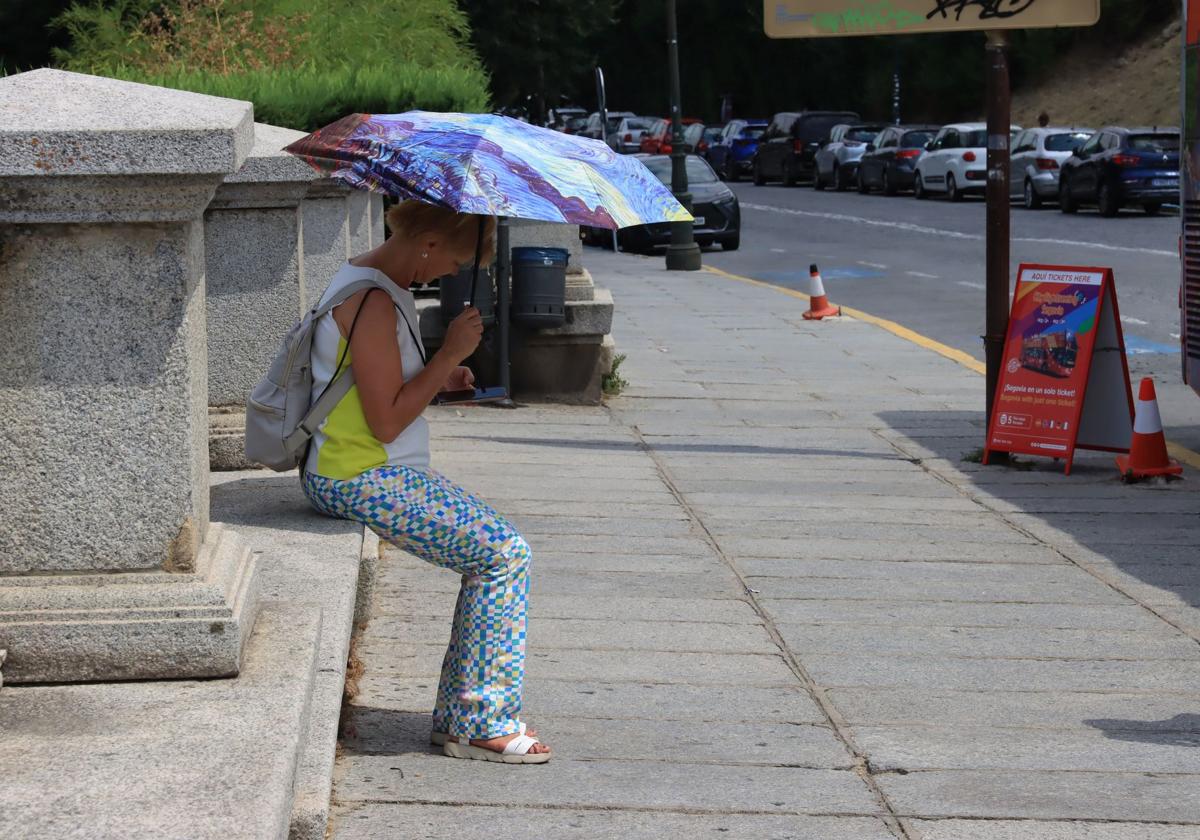 Una mujer se protege del sol en Vía Roma.