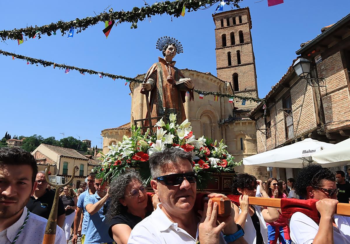 Peñistas y cofrades portan la imagen de San Lorenzo a la salida de la iglesia del barrio, este sábado.