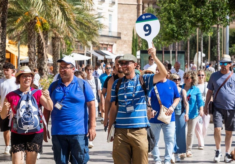 Un guía turístico encabeza una visita por el centro de Valencia.