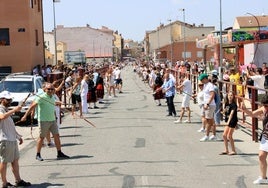 Dos filas de personas, una a cada lado de la carretera de Sebúlcor en Cantalejo, se preparan con sus trallas para el récord.