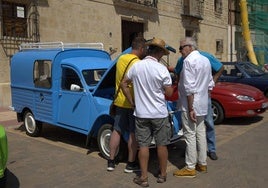 Varios aficionados, en torno a los coches expuestos.