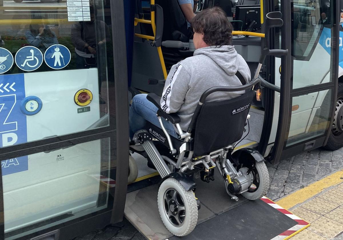 Una persona en silla de ruedas sube a un autobús por la rampa.