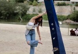 Una chica utiliza las duchas de la Playa de las Moreras