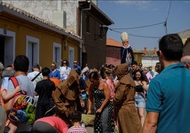 El abad Reinoso preside el desfile, mientras el público recoge regalos.