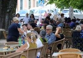 Varias personas disfrutan de la jornada festiva en una terraza.