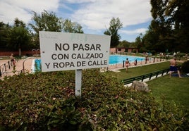 Un cartel advierte sobre las normas de uso en la zona de baño de la piscina Juan de Austria.