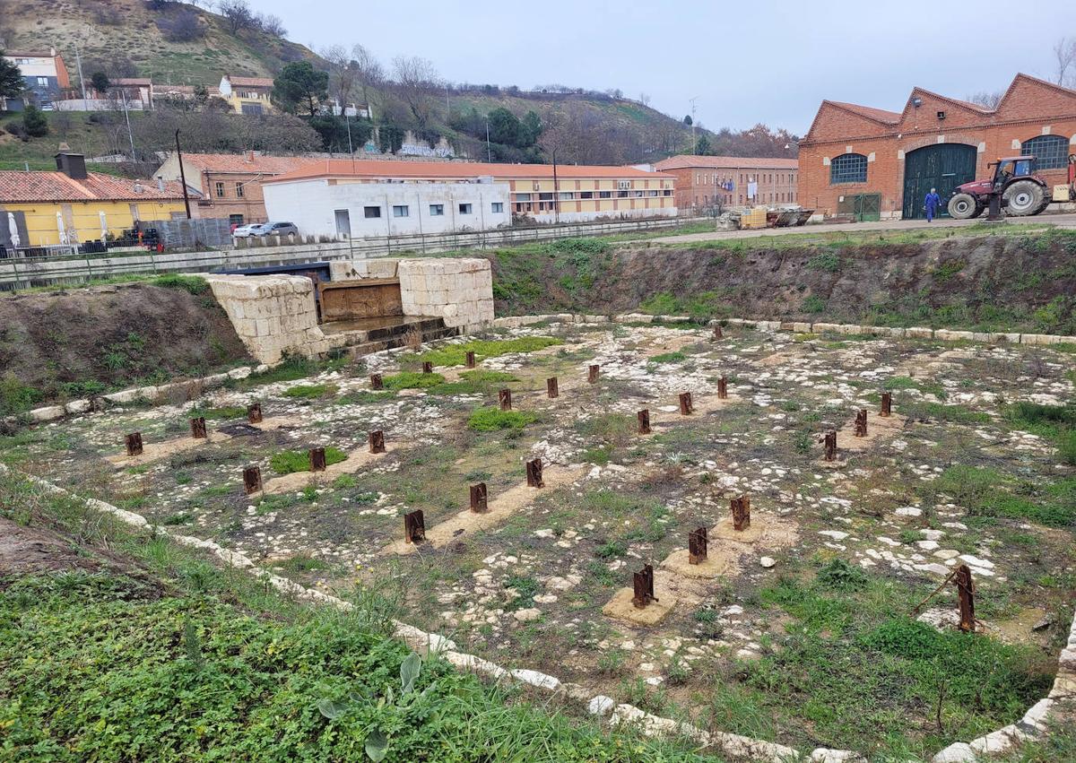 Imagen secundaria 1 - Foto 1: La fachada trasera de la fábrica La Perla, con la entrada del derrame del canal para suministro de fuerza motriz. Foto 2: Compuerta del canal y apoyo de los postes de sujeción de las barcas, visibles durante las obras de limpieza de la dársena realizadas en 2023. Foto 3: Imagen actual de la dársena del canal. 