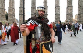 Un hombre vestido de soldado romano posa junto al Acueducto.