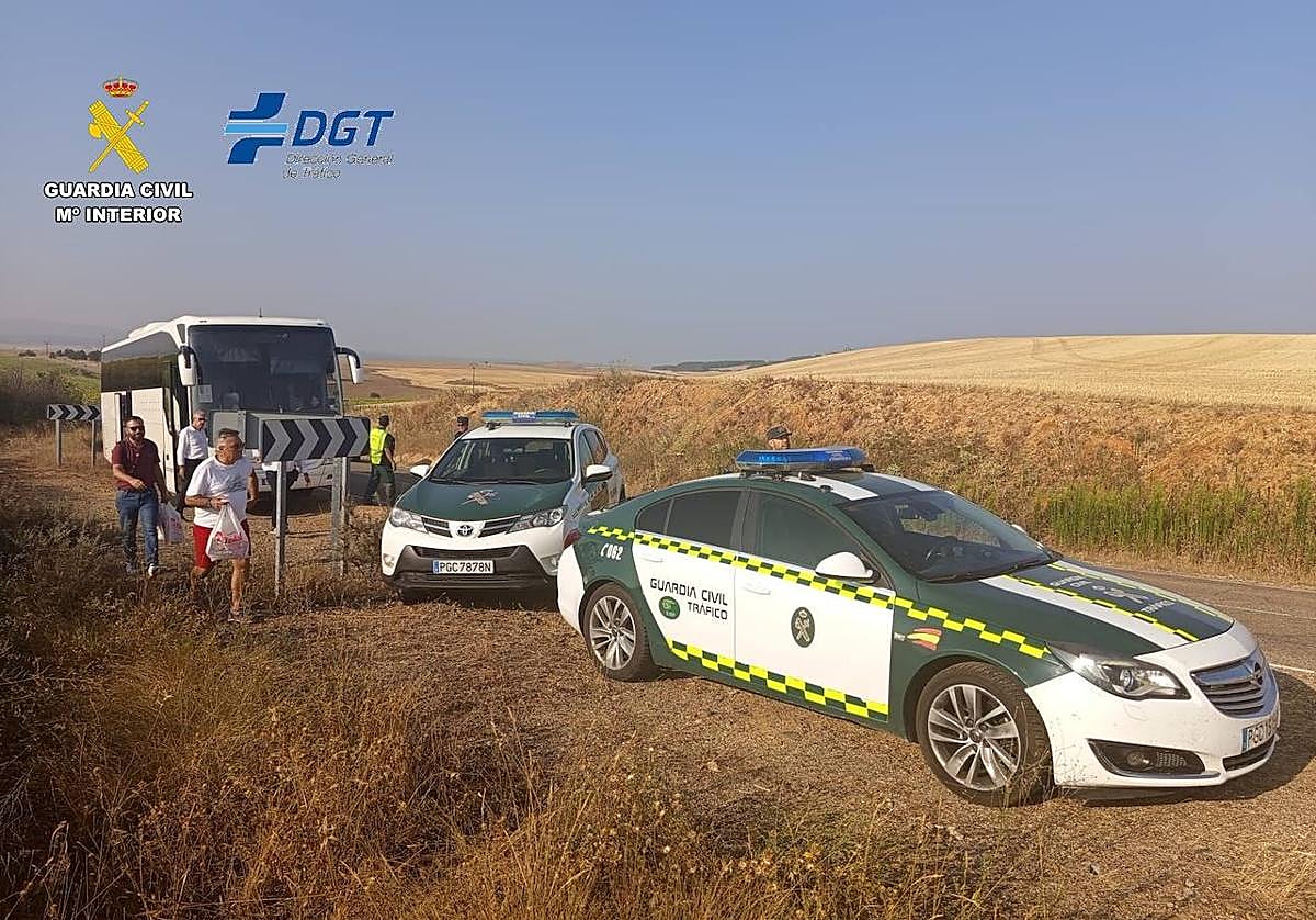 La Guardia Civil traslada a los pasajeros del autobús averiado.