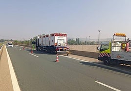 Camión averiado y zona señalizada en el lugar del accidente.