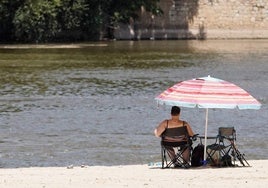 Una mujer se refresca junto al Pisuerga en la playa de Moreras.