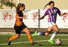 Una jugadora del Real Valladolid Simancas se lleva el balón ante la oposición de una rival.