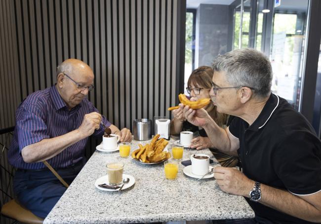 Jesús Cantalapiedra, Aurora Izquierdo y Mariano Izquierdo disfrutan de un chocolate con churros.