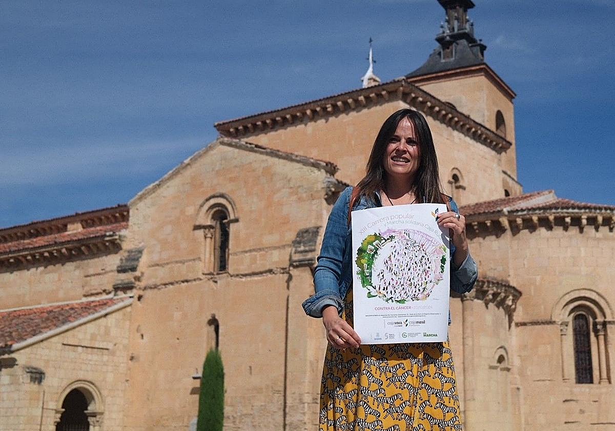 La artista Raquel Bartolomé posa con el cartel que anuncia el evento deportivo.
