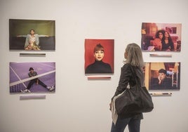 Una mujer observa varias de las fotografías de la exposición.