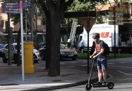 Un joven transita por Palencia con un patinete eléctrico.