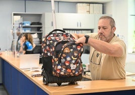 El agente Manuel Navarro inspecciona el contenido de una mochila depositada por la Policía Nacional en la Oficina de objetos hallados.