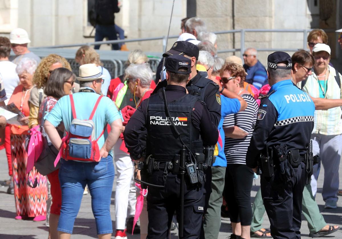 Agentes policiales vigilan a un grupo de turistas para evitar carteristas en la ciudad.