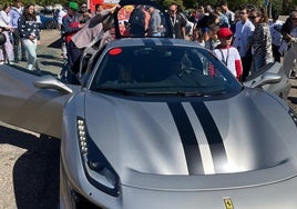 Niños y familias participantes examinan un Ferrari frente al Estadio José Zorilla.