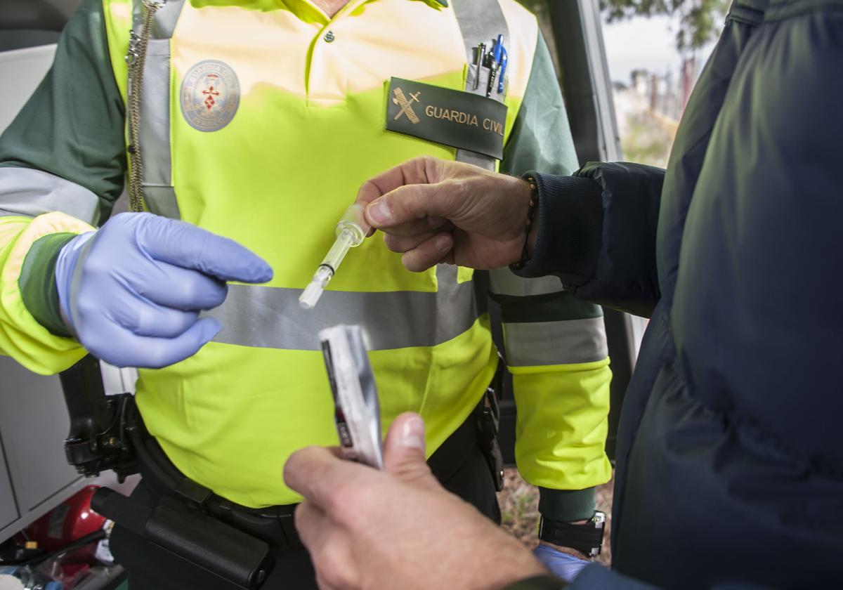 Conductor procede a realizar una prueba de drogas en un control de la Guardia Civil.