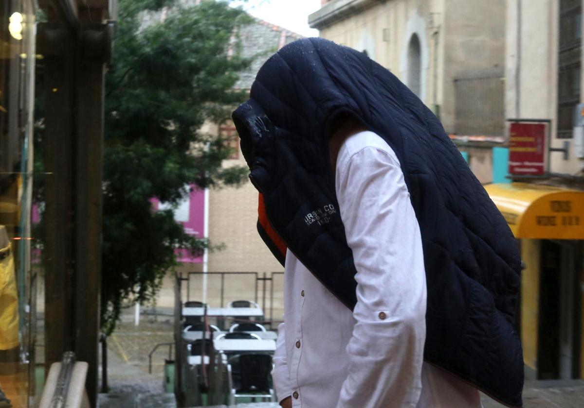 Un hombre se protege de la lluvia en Segovia, en una imagen de archivo.