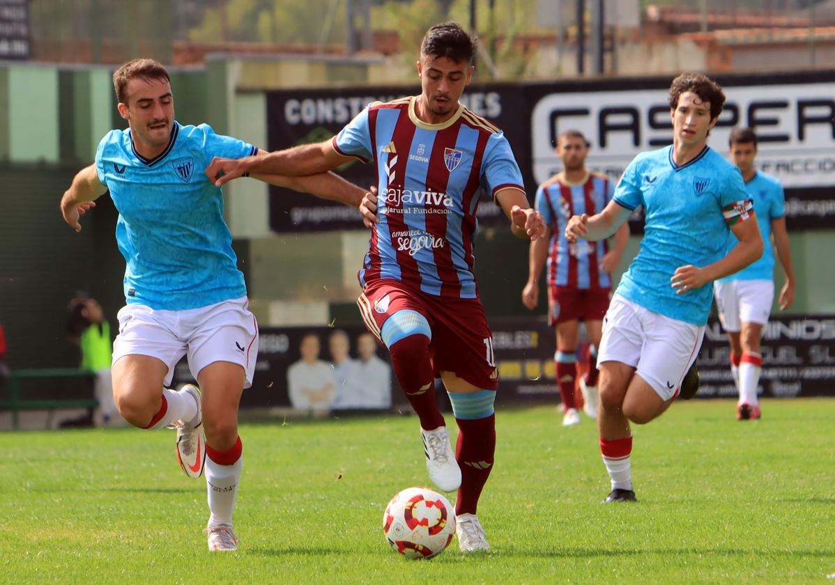 Javi Borrego conduce perseguido por un jugador del Bilbao Athletic.