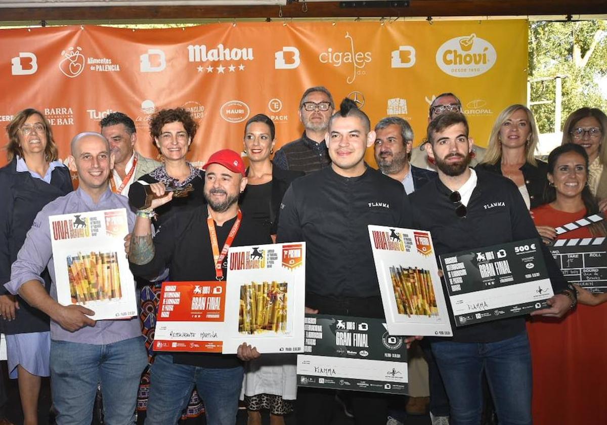 El primer premio levanta la estatuilla del Cristo, a la derecha, los dos cocineros de Flamma Valladolid, y a la izquierda, el tercera galardonado, en una foto de familia con organizadores y patrocinadores.