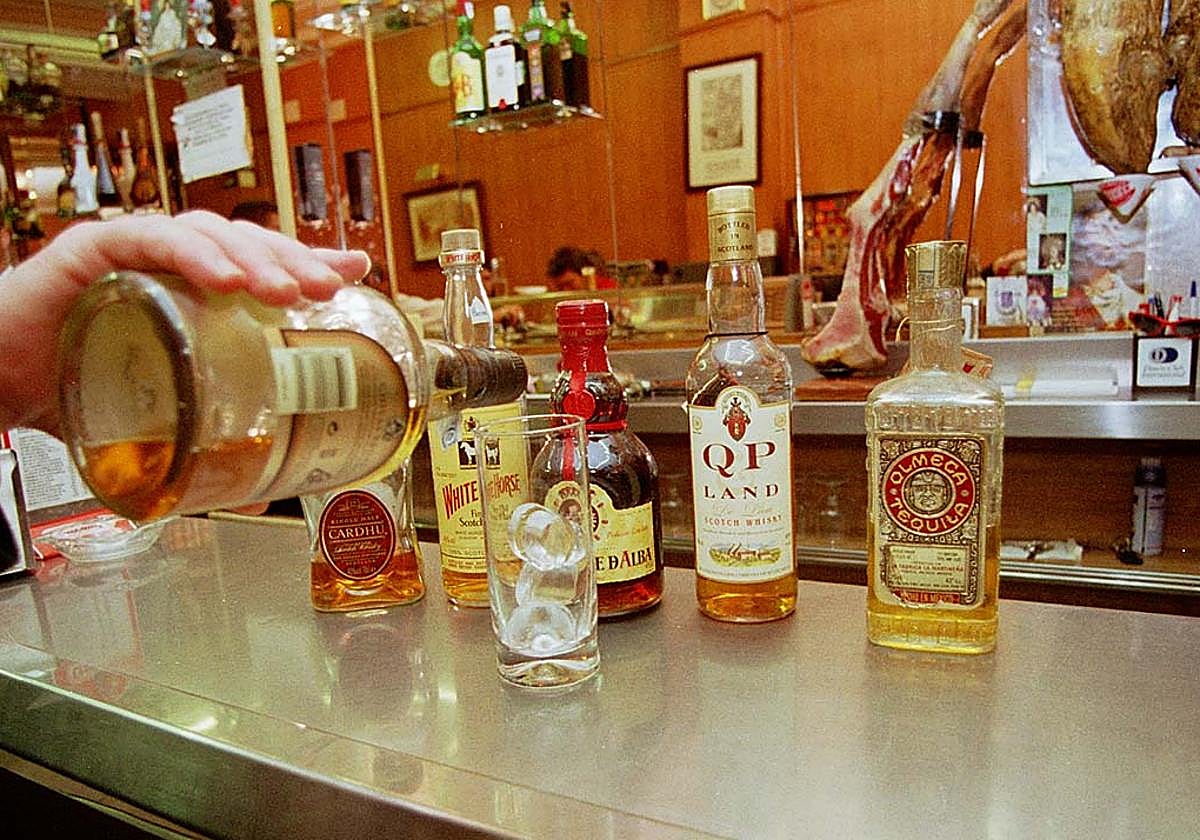 Un camarero sirve una copa en un bar.