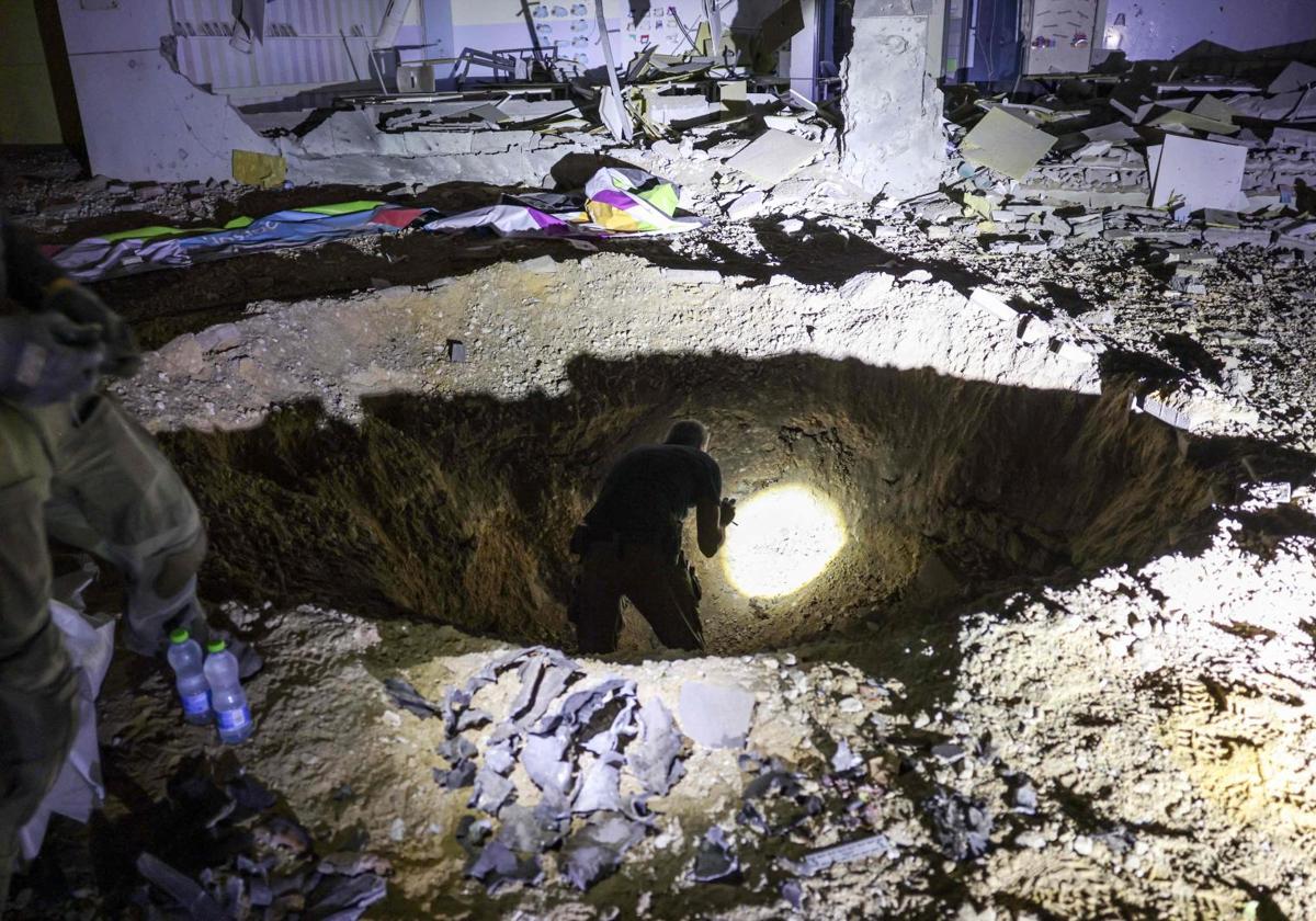 Policía israelí inspecciona el cráter de un misil que no explotó.