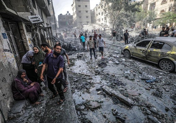 Palestinos en una zona destruida tras los ataques aéreos israelíes en la ciudad de Gaza en octubre del año pasado.