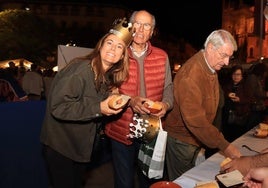 Dos personas participan en la entrega de viandas de Isabel en la Plaza Mayor.