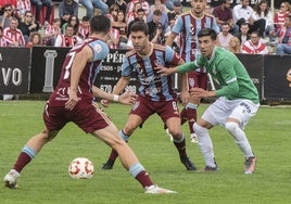 Manu intenta jugar la pelota presionado por un jugador del Zamora.