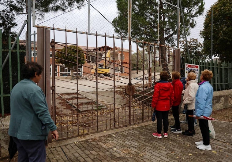 Vecinos de Dueñas observan los trabajos de derribo del colegio de Dueñas.