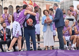 Presentación del equipo de baloncesto en la Plaza Mayor, con alcalde y concejala recibiendo dos balones de manos de Peral y De la Fuente.