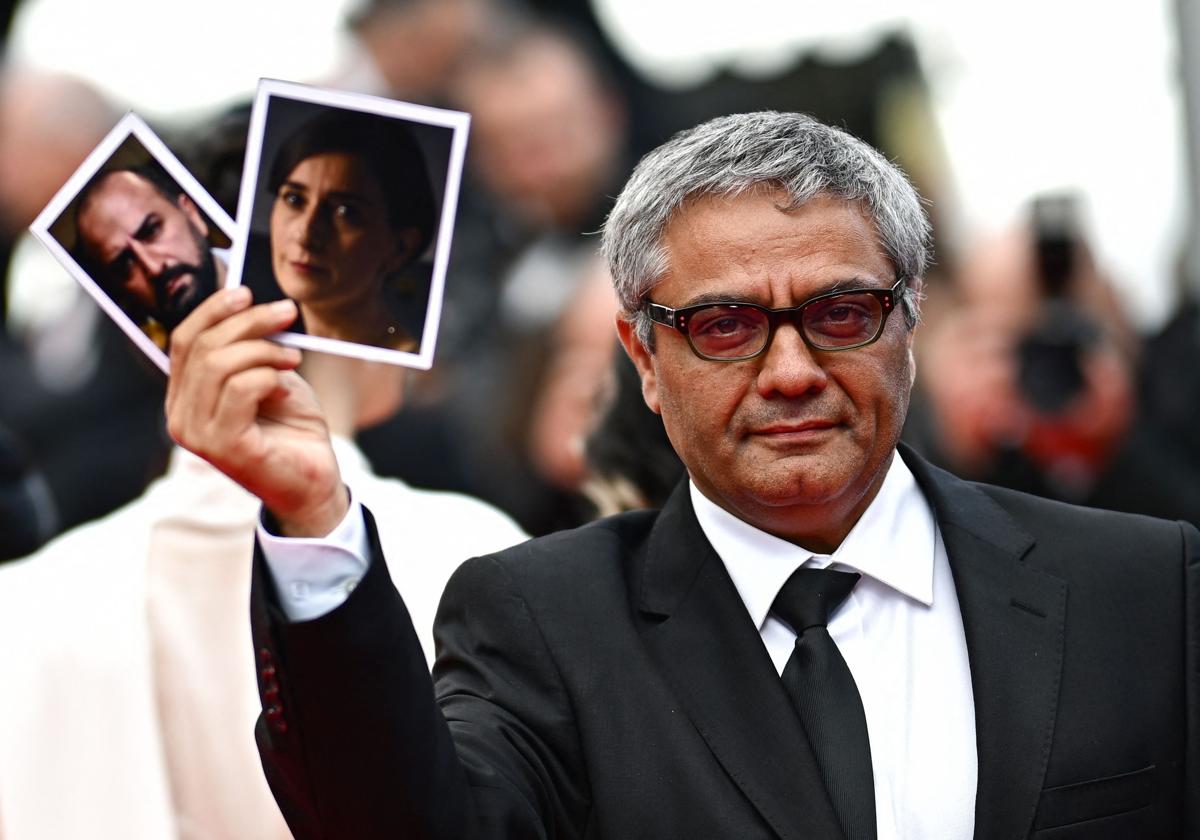 Mohammad Rasoulof, en el pasado Festival de Cannes, con los retratos de sus actores.