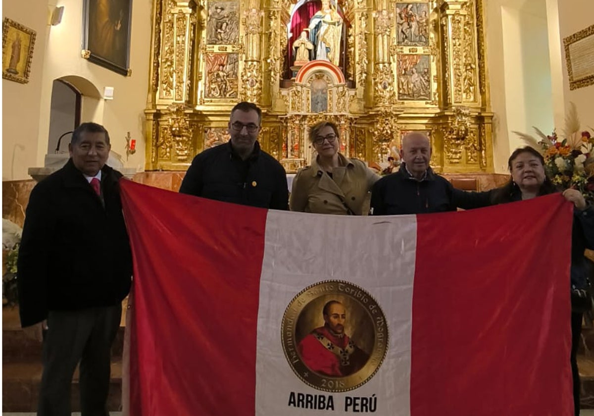 El matrimonio en su visita a la ermita con una bandera peruana con la imagen del santo