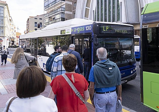 Varios usuarios del nuevo servicio de lanzaderas entre barrios se suben a uno de los autobuses.