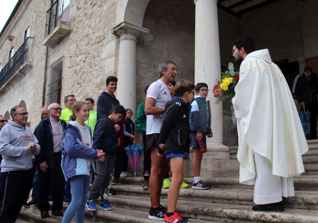 El último relevista entrega el ramo de flores al sacerdote que aguardaba en el santuario.