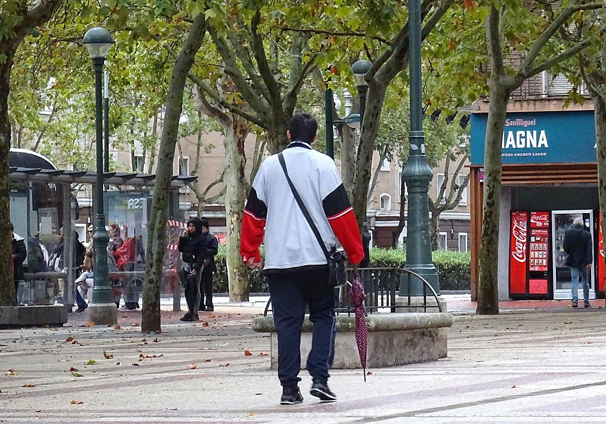 Un hombre pasea con su paraguas en el Paseo de Zorrilla.