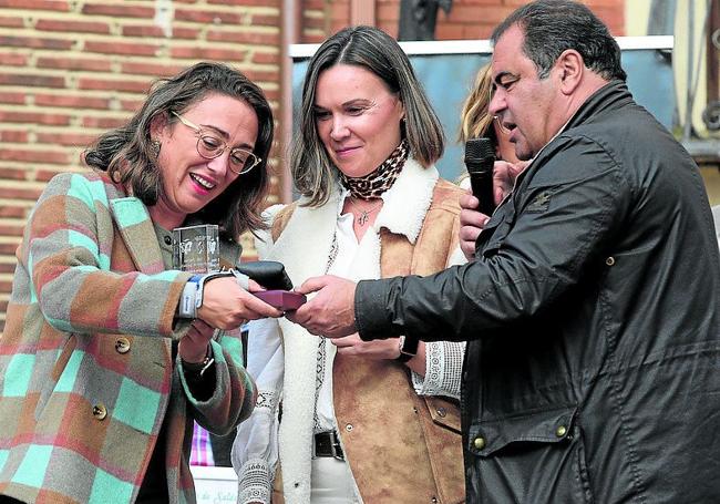 La consejera de Agricultura, a la izquierda, recibe el reconocimiento, entregado por el alcalde de Saldaña, Adolfo Palacios.