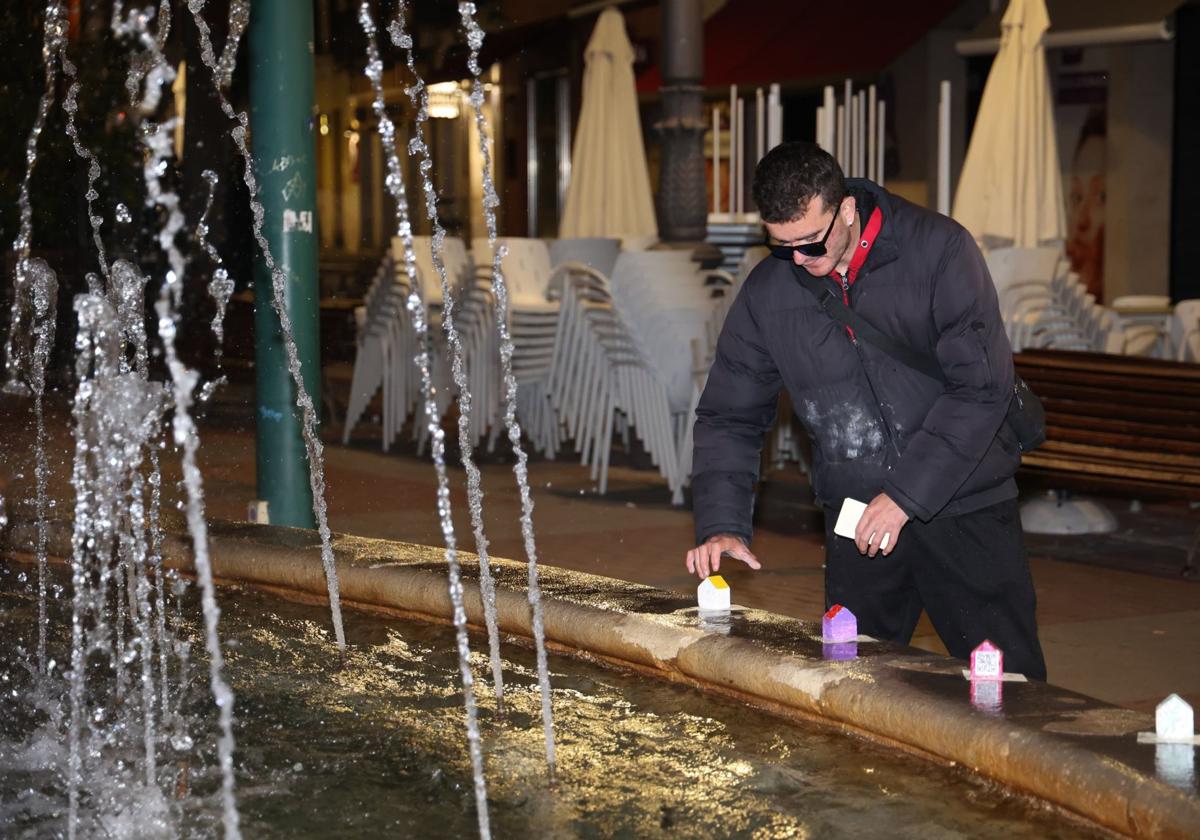 Un voluntario coloca casitas en la fuente de la Plaza de España, anoche.