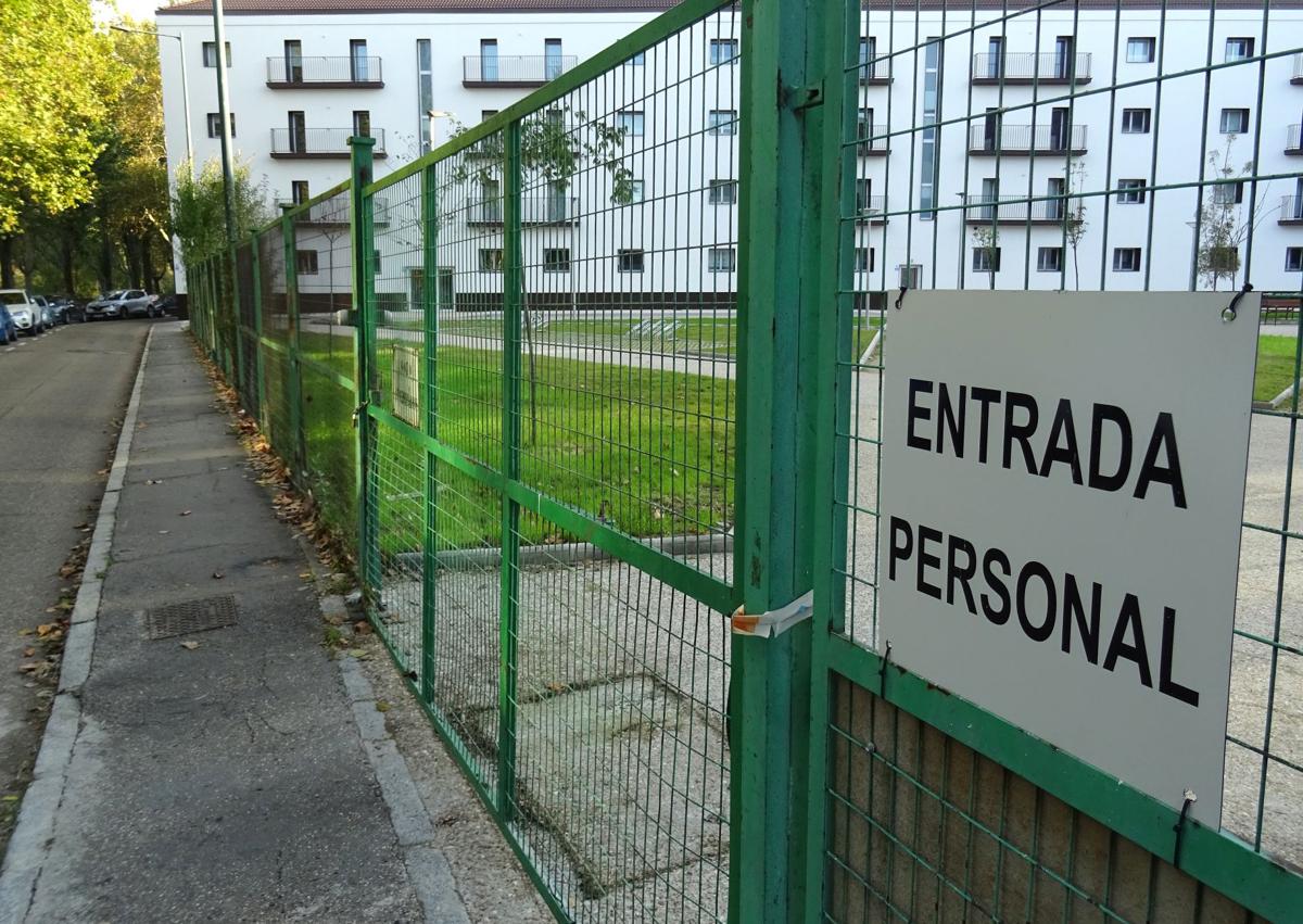 Imagen secundaria 1 - Arriba, el único acceso a la plaza que carece de verja. Debajo, a la izquierda, el cartel de obra para la 'entrada del personal'. A la derecha, aceras de brea en el perímetro de la plaza por el paseo del Cid visto desde Puente Colgante.