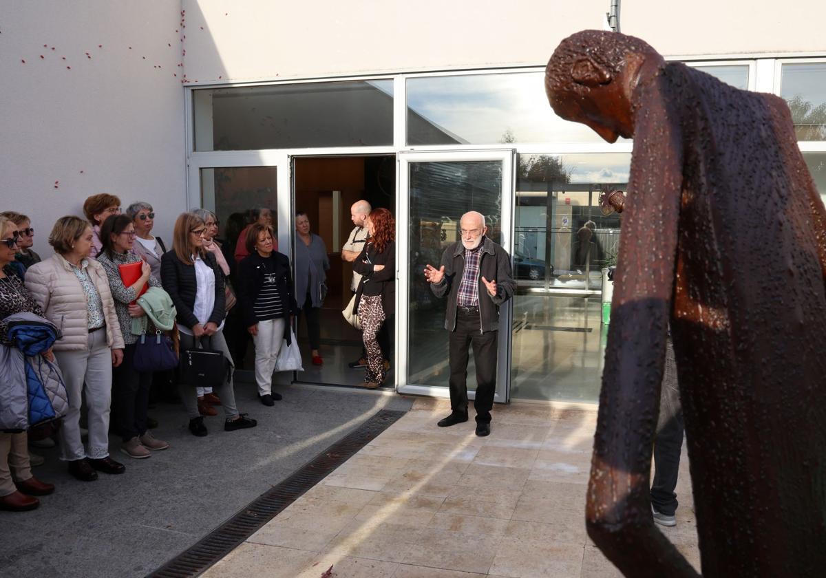 El escultor Adolfo Revuelta, en el centro, explica la obra a los participantes en la visita.