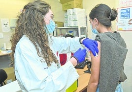 Una enfermera vacuna a una joven en la campaña de la gripe de la temporada pasada.