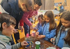 Personas del taller ocupacional guían a los alumnos en sus creaciones