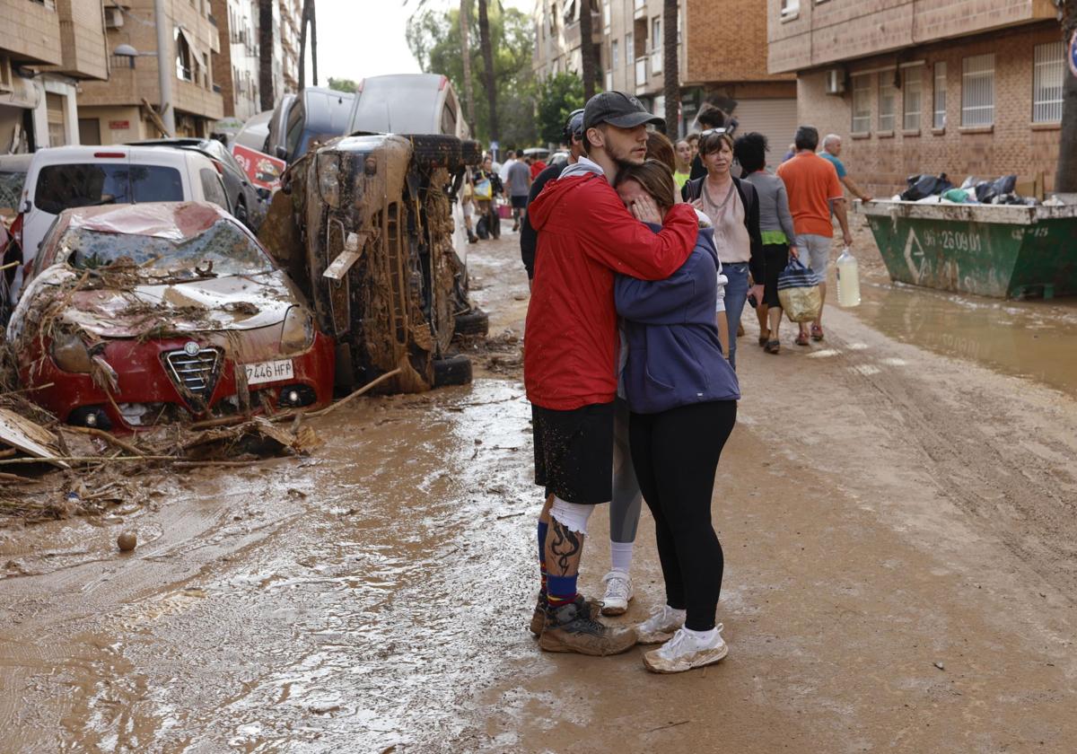 Dos personas se abrazan en Paiporta, una de las localidades valencianas afectadas por la DANA.