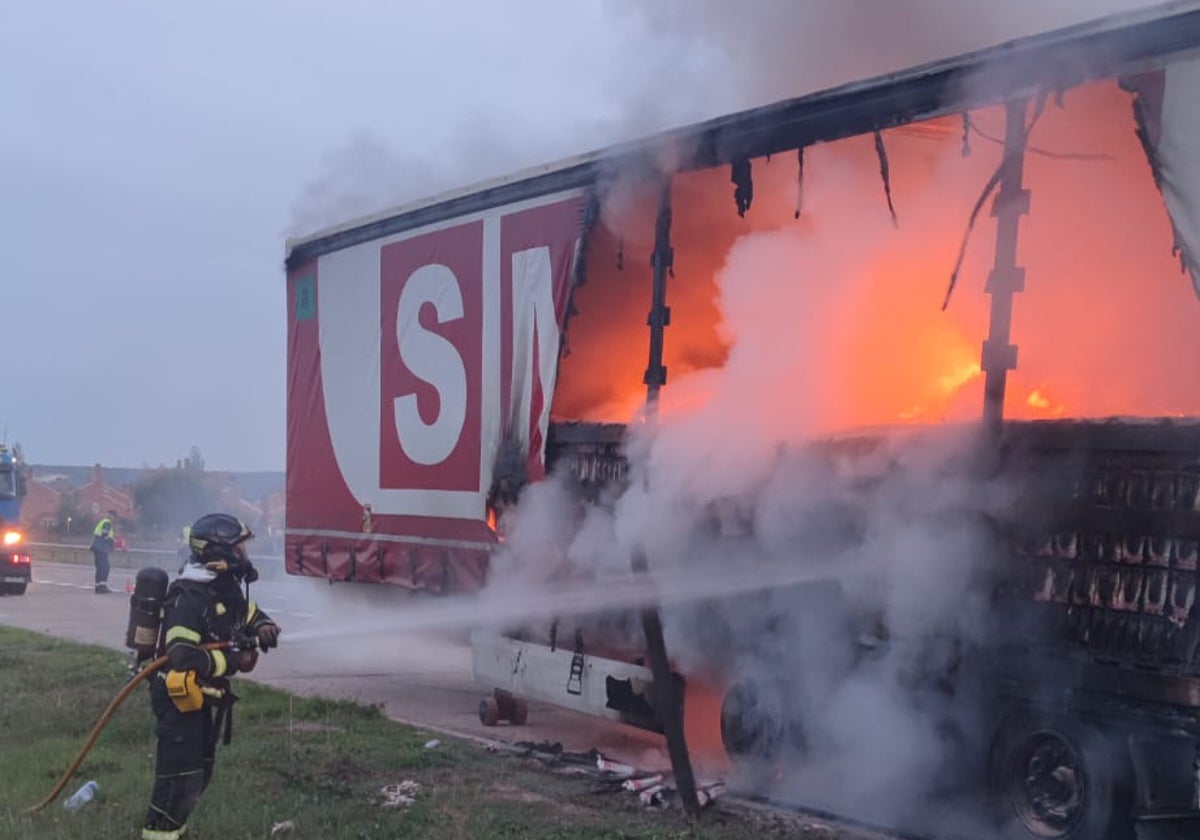 Uno de los bomberos interviniendo en la extinción de las llamas de la caja del tráiler.