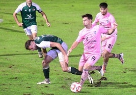 Fer Llorente conduce ante un jugador del Cacereño.