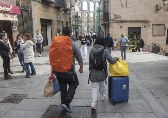 Dos personas caminan con maletas por la Calle Real este jueves.